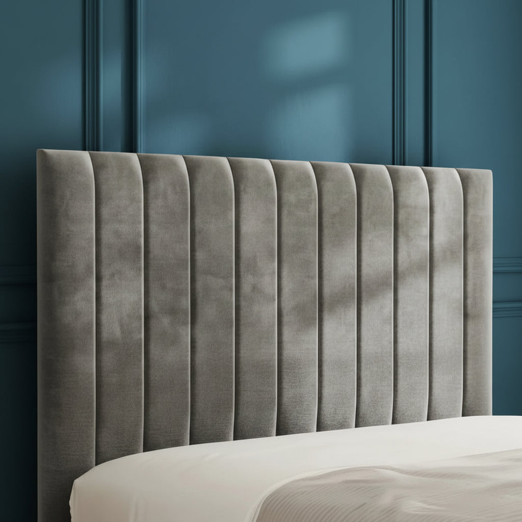 Gray upholstered headboard on a bed with a neutral background