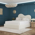 Luxurious bedroom with a large bed, decorative pillows, and a chandelier.
