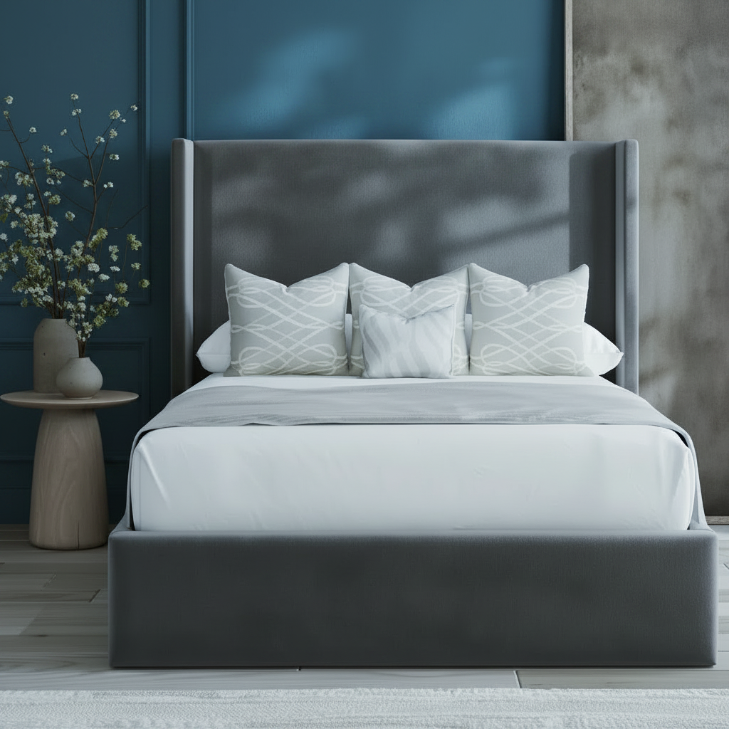Bedroom with a bed featuring gray upholstered headboard and white bedding, next to a wooden side table with decorative elements.