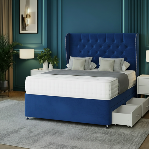 Gray upholstered bed with tufted headboard in a bedroom setting with blue walls and white nightstands.