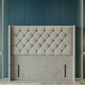 Decorative headboard against a marble wall with lighting