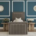 Gray upholstered bed in a stylish bedroom with decorative elements.