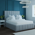 Gray upholstered bed in a modern bedroom with white bedding and decorative pillows.