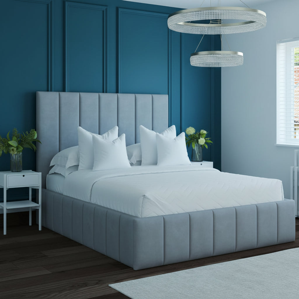 Gray upholstered bed in a modern bedroom with white bedding and decorative pillows.