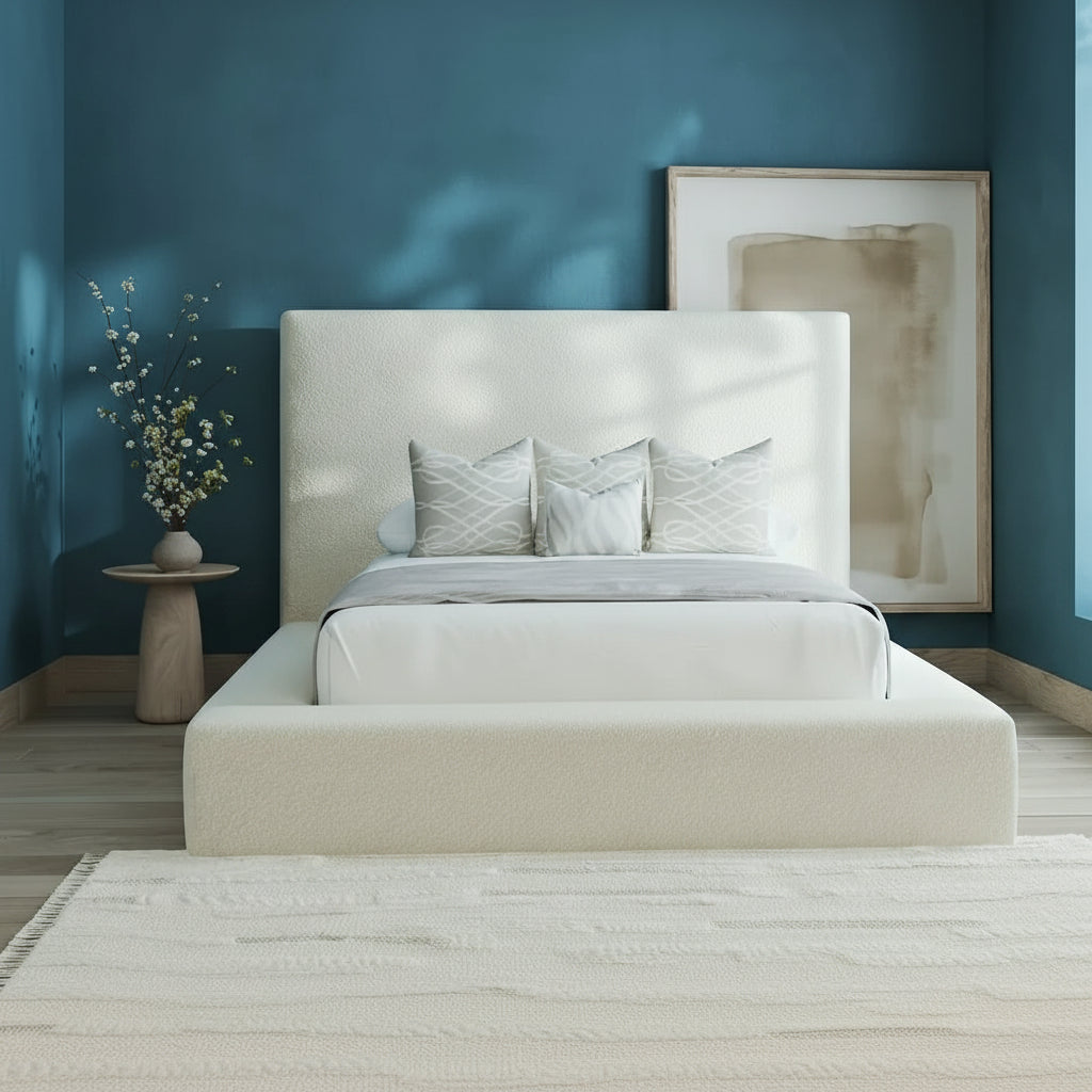 Beige upholstered bed in a room with a large window and abstract art on the wall.