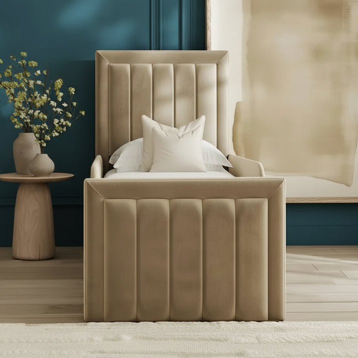 Beige upholstered chair with white cushions in a room with abstract art and a small table.